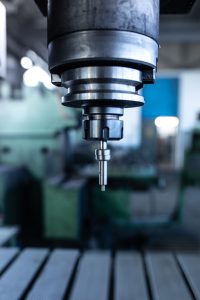 industrial metal drill machine in metalworking workshop.